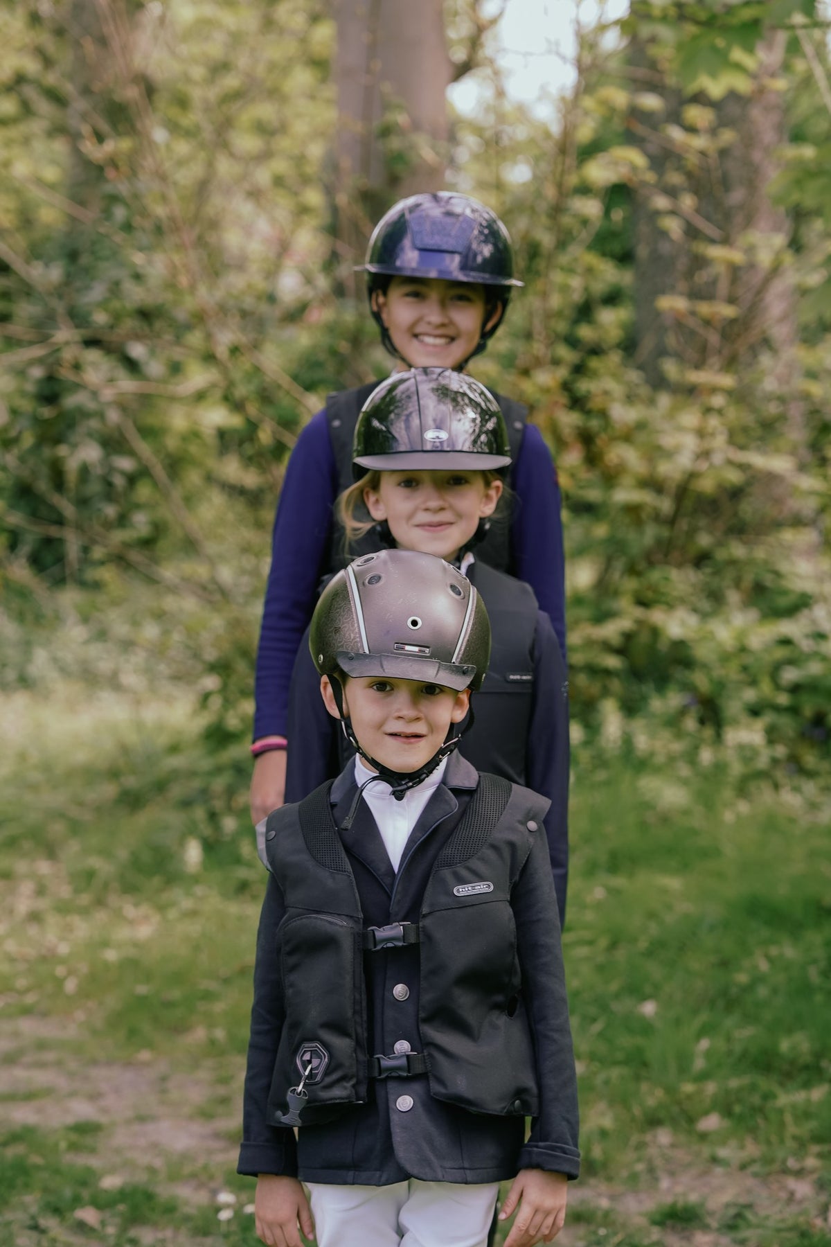 Trois enfants cavaliers portant des gilets airbag Hit-Air de tailles différentes
